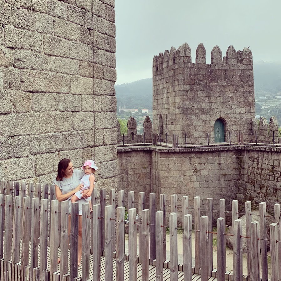 Summer and her daughter by the stone towers of Guimarães Castle