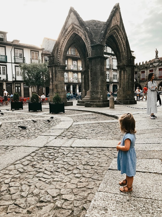Toddler looking at the Padrão do Salado arch in Largo da Oliveira, Guimarães