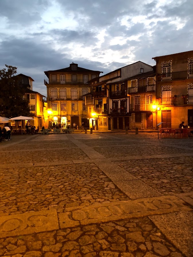 Largo da Oliveira square lit up at dusk in Guimarães