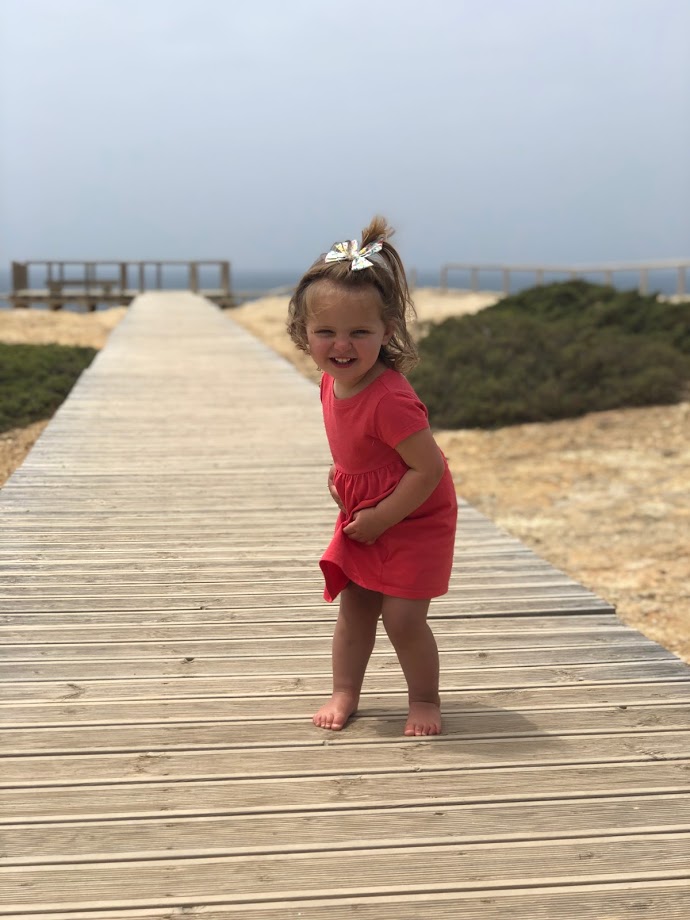 Toddler dancing on the boardwalk at Pontal da Carrapateira