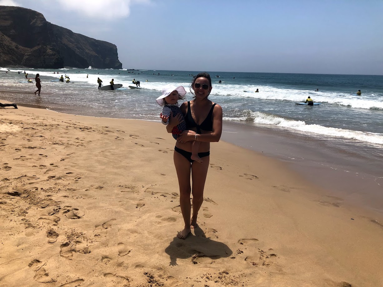 Summer holding her daughter on the sand at Praia da Arrifana