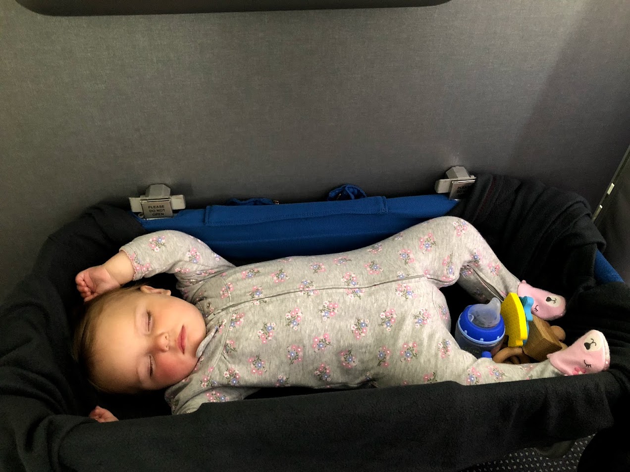 Baby asleep in the airplane bassinet