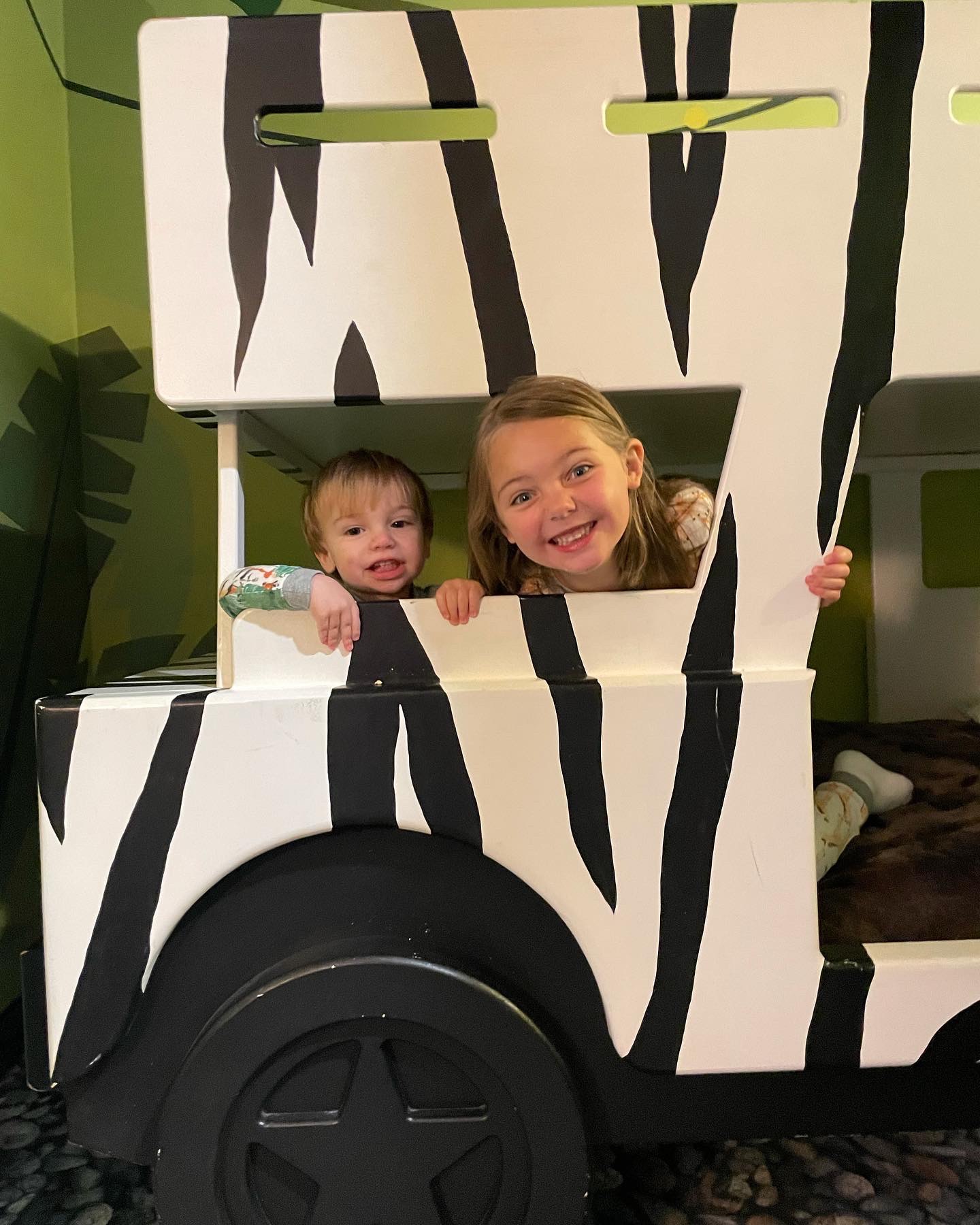 Summer's kids peeking out of the zebra-striped safari bunk at Kalahari