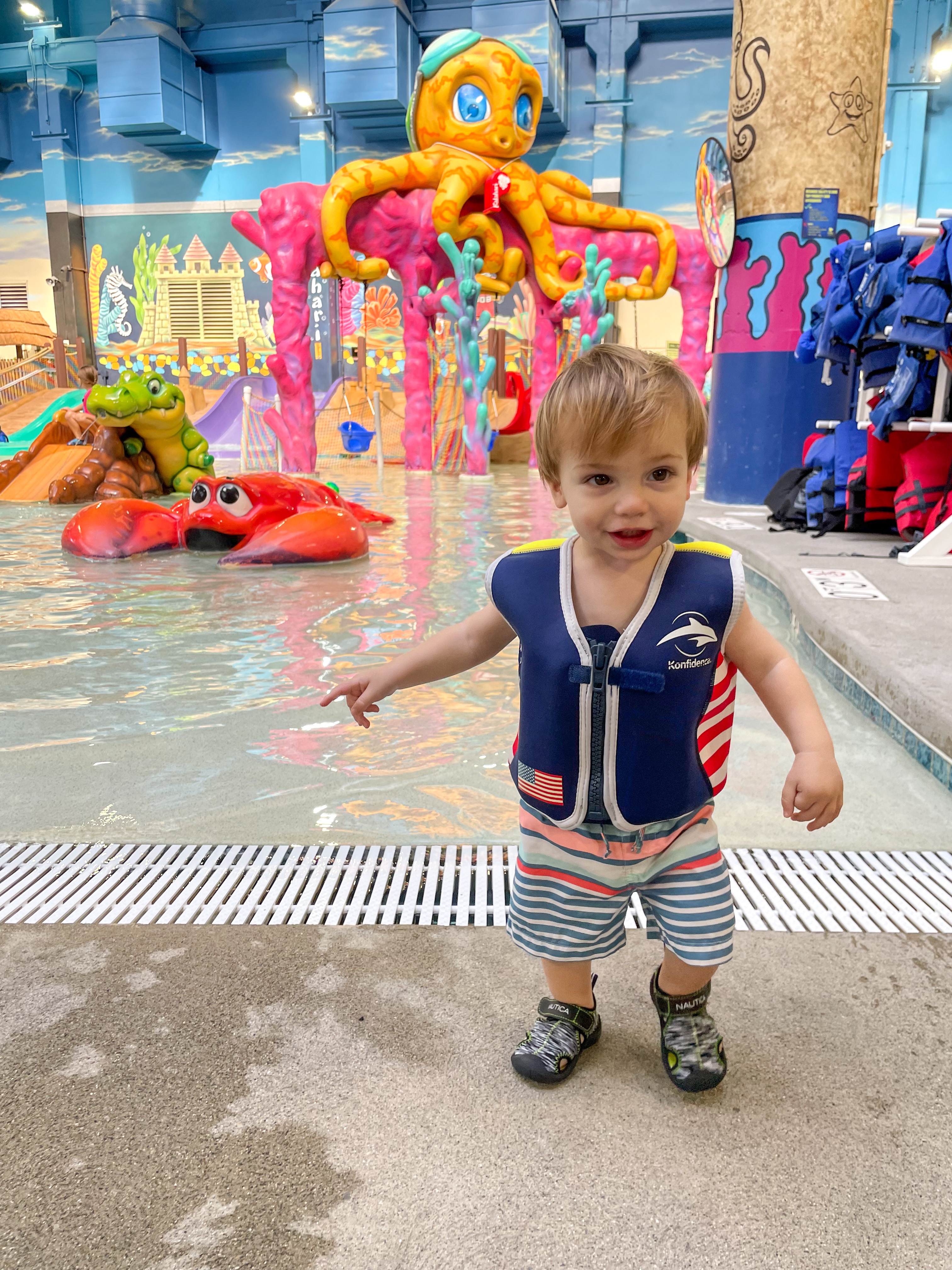 Toddler in a life vest and water shoes at Coral Cove, Kalahari