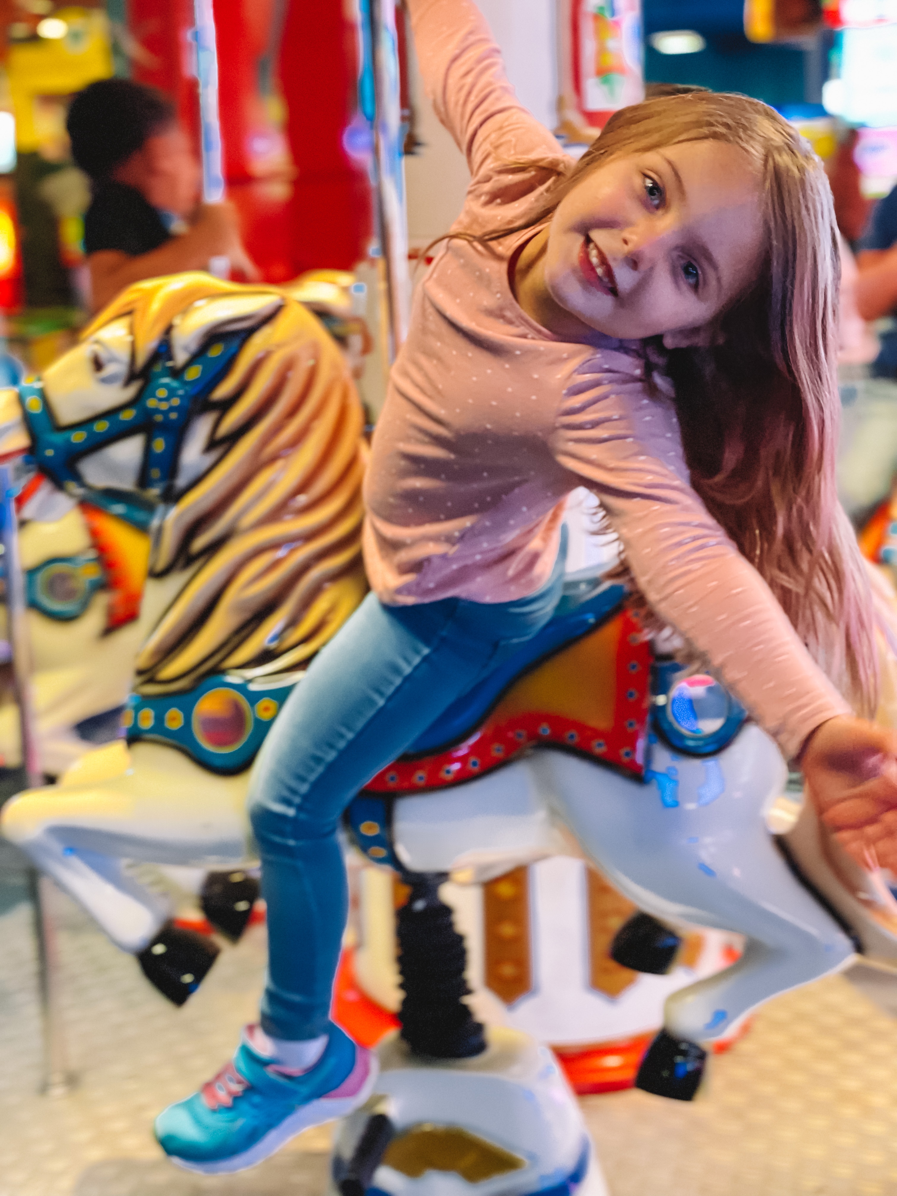 Summer's daughter riding a carousel horse in the Kalahari arcade