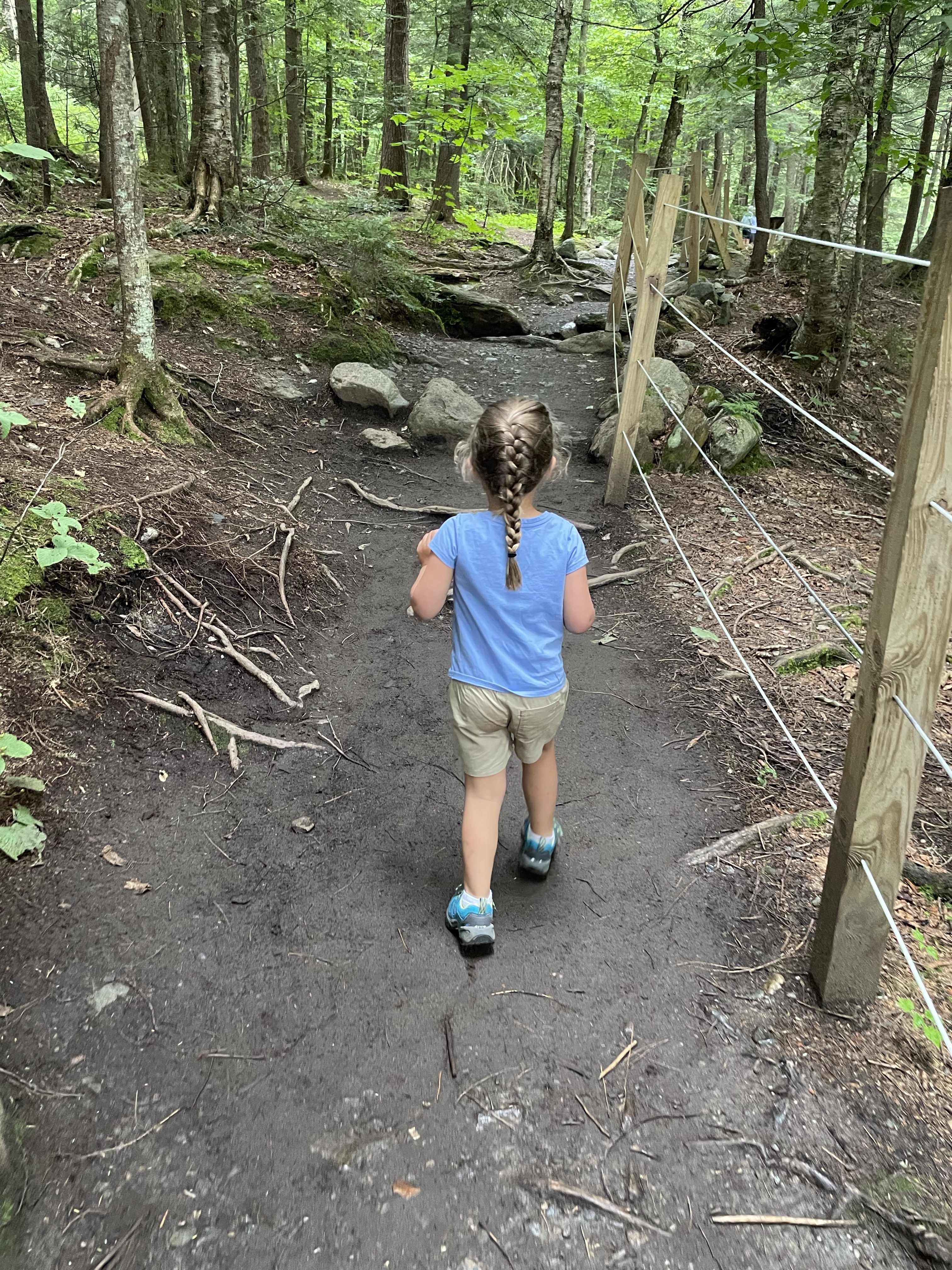 Summer's daughter hiking a forest trail in Stowe