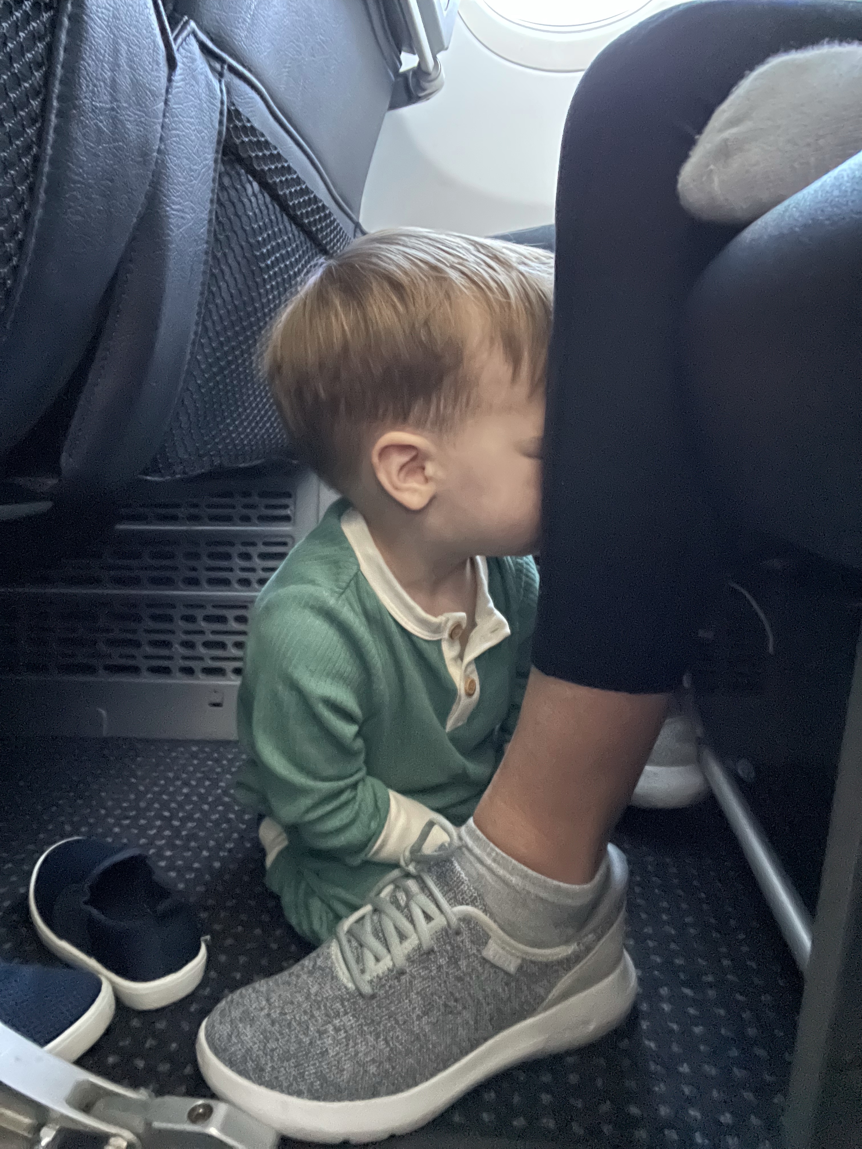 Toddler playing on the floor at Summer's feet on the plane