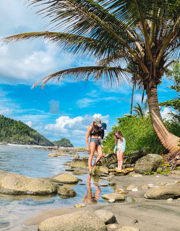 Summer and her kids on the rocks at the shore in Dominica