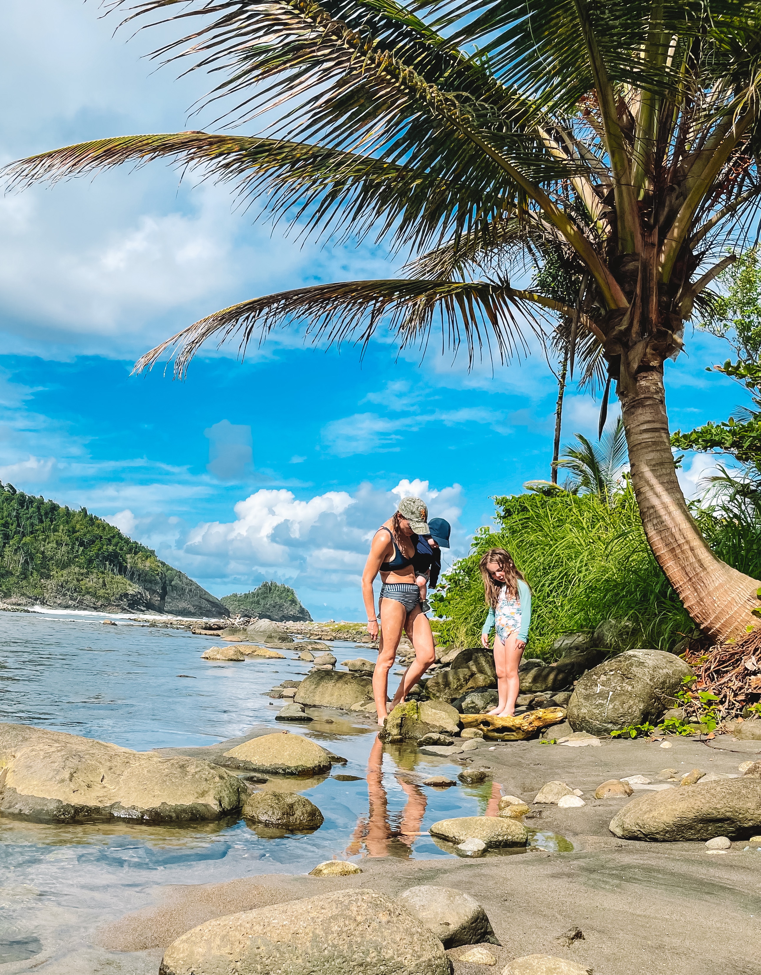 Summer and her kids on the rocks at the shore in Dominica