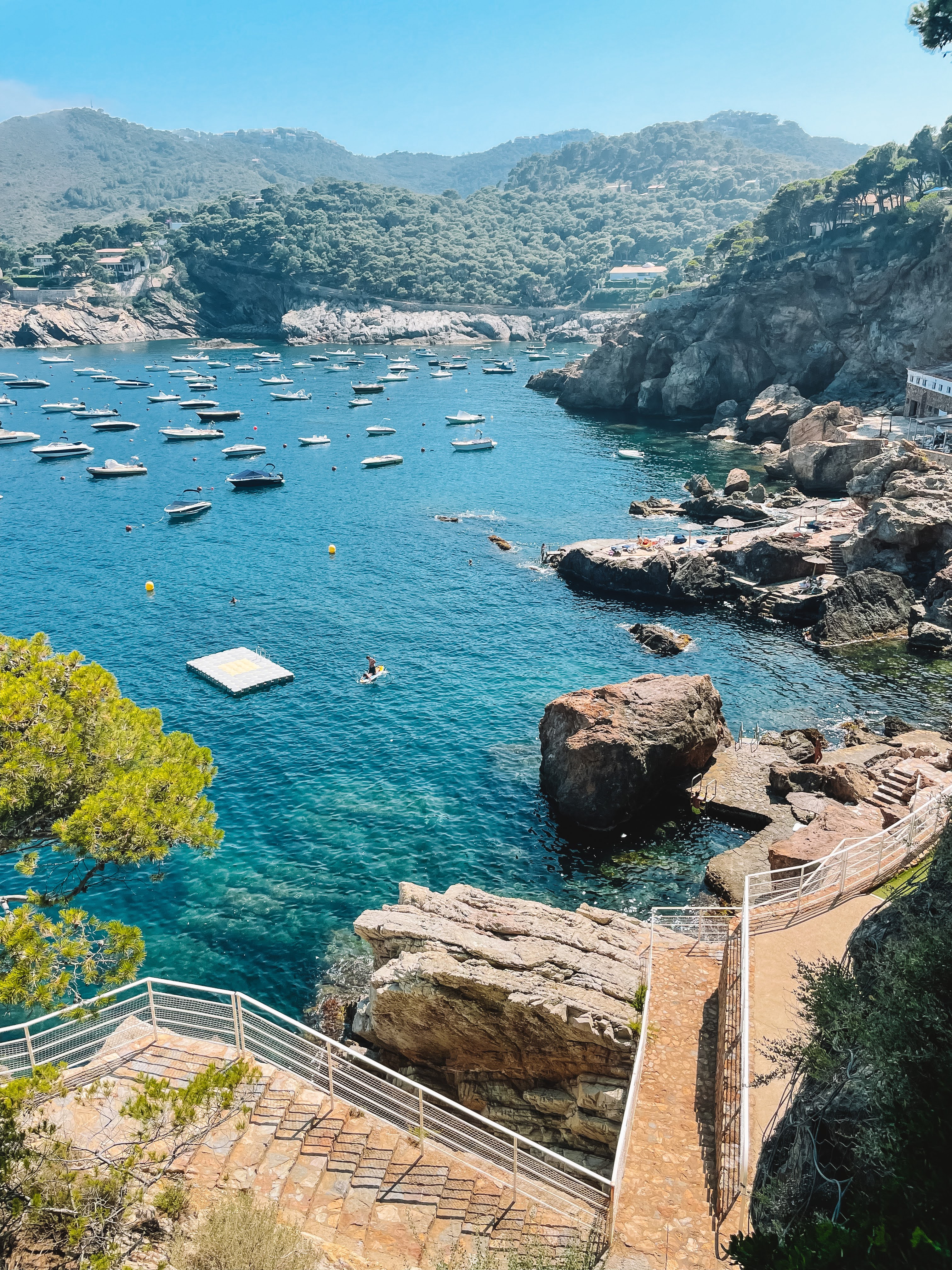 Boats moored in the turquoise bay at Cala d'Aiguafreda, Costa Brava